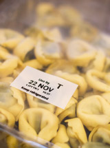 image of a plastic container of fresh pasta with a Use By date printed on the label