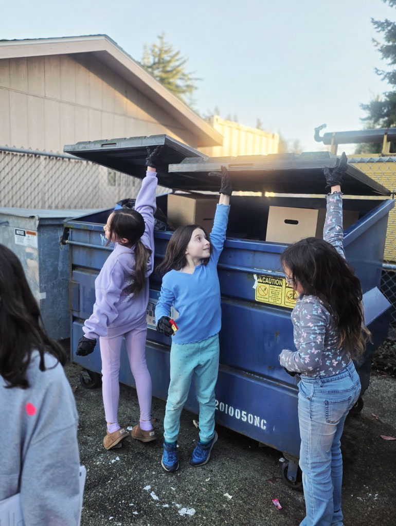 Students from Lakeridge Elementary School on Mercer Island measure the size of their trash dumpster and figure out how full it is. 