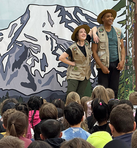 The assembly entertains and educates students about waste reduction, recycling, and composting