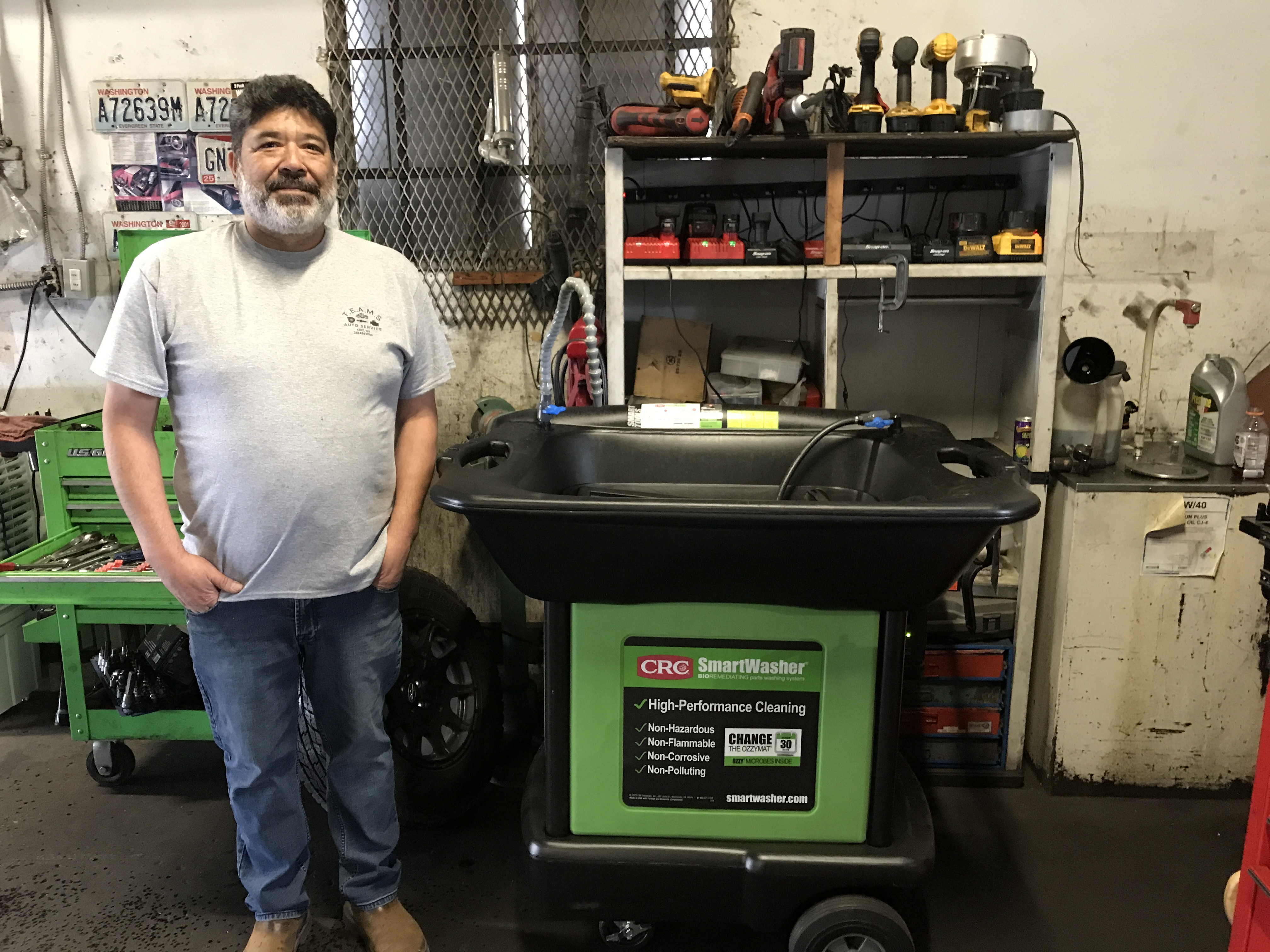Miguel Martinez, owner of Teams Auto Services in Kent, stands in front of smart washer.