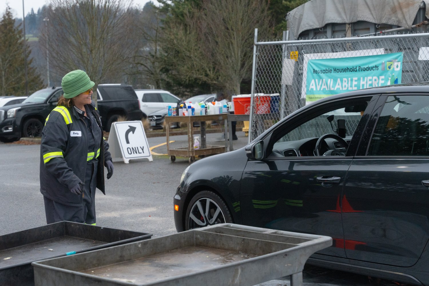 Woman smiles at person in a car visiting a hazardous waste disposal facility