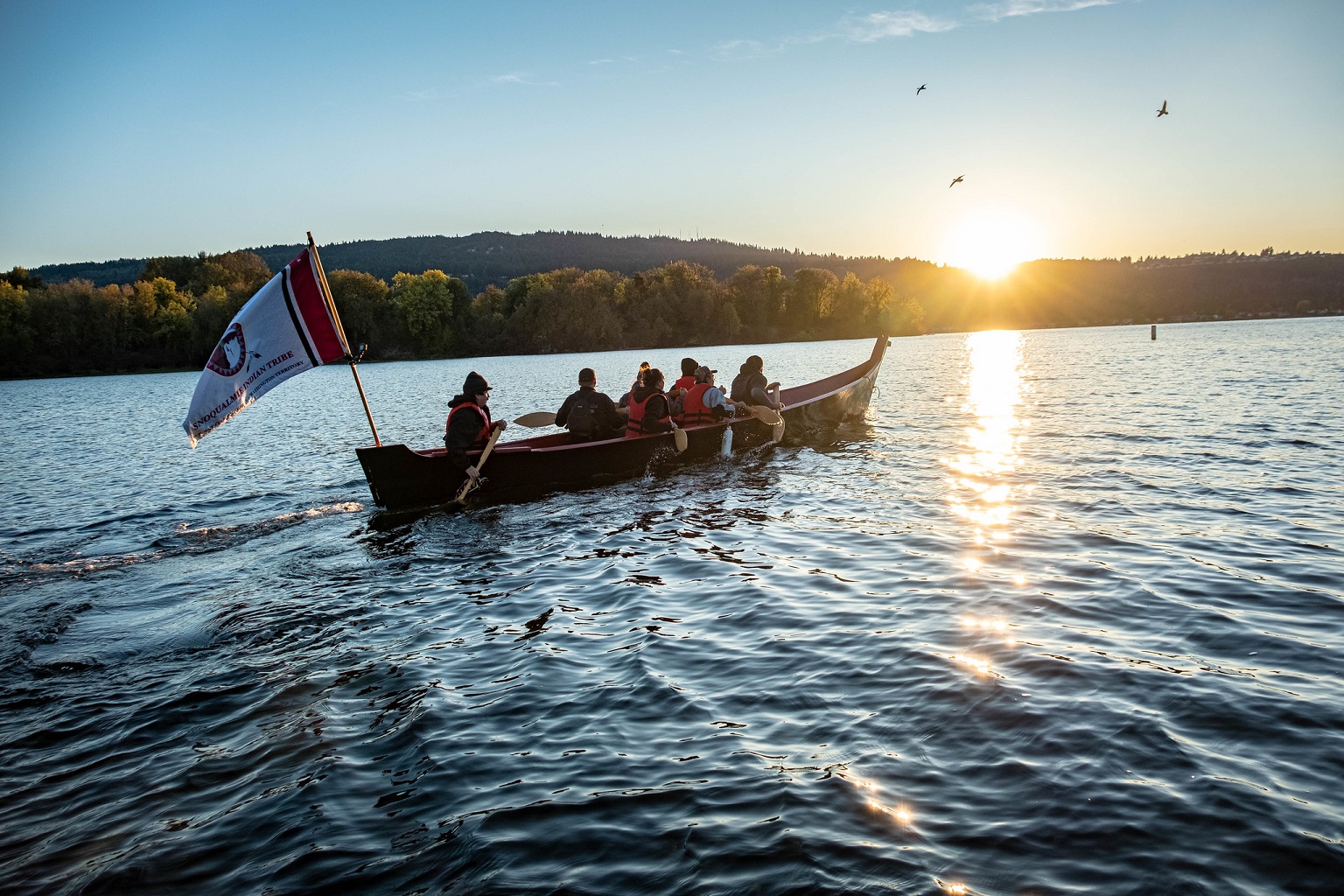 Indigenous people on a canoe on a lake