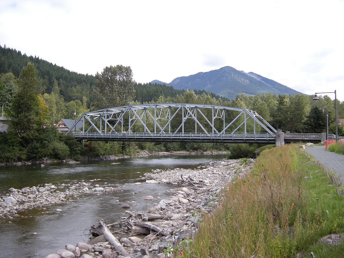 bridge over river with mountain in the background