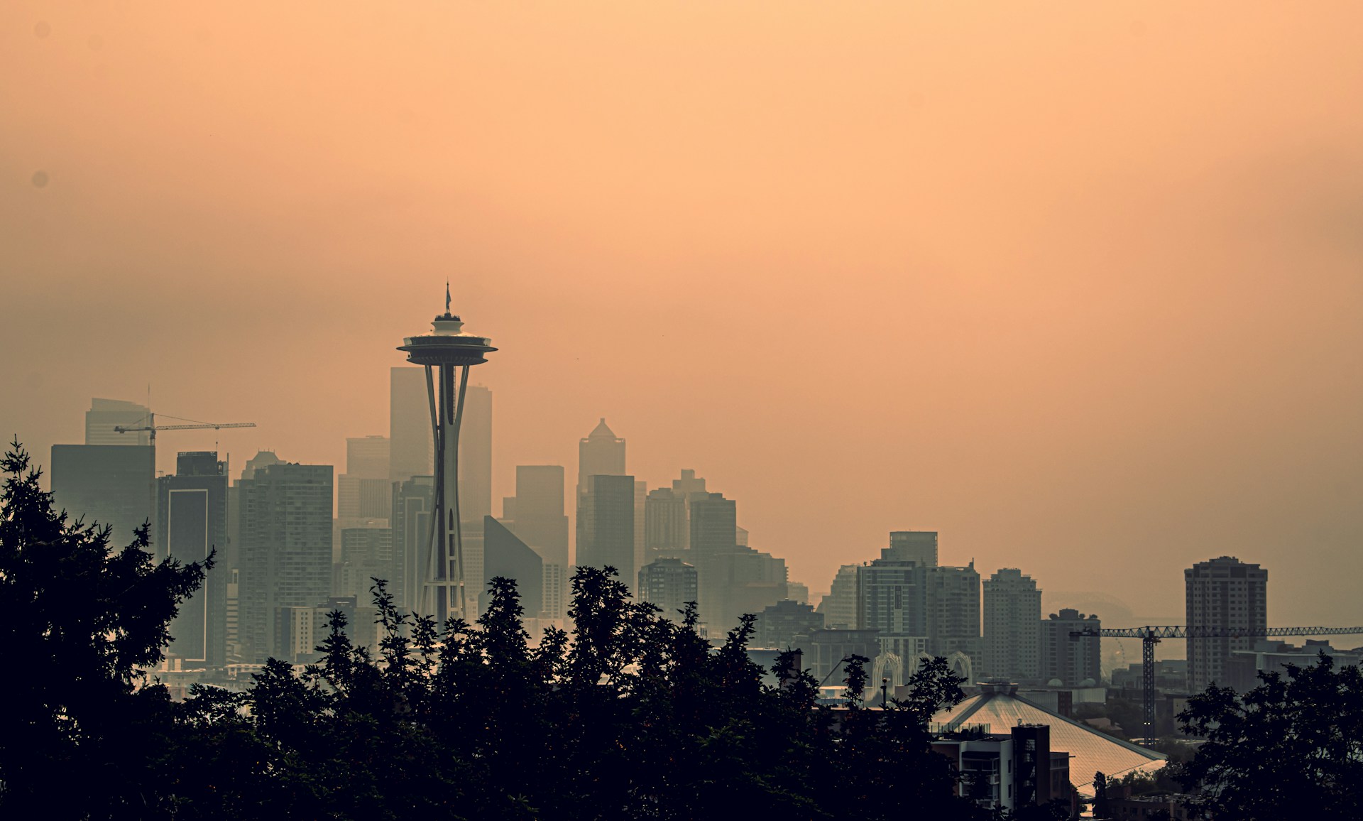 Skyline of Seattle with an orange, smoky sky. 