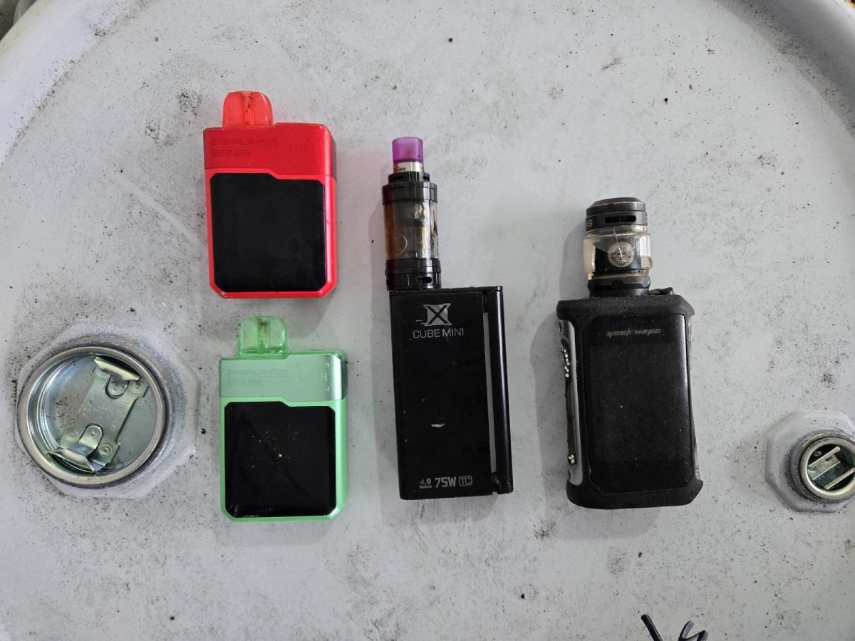 Four different types of vape pens laid out on table.