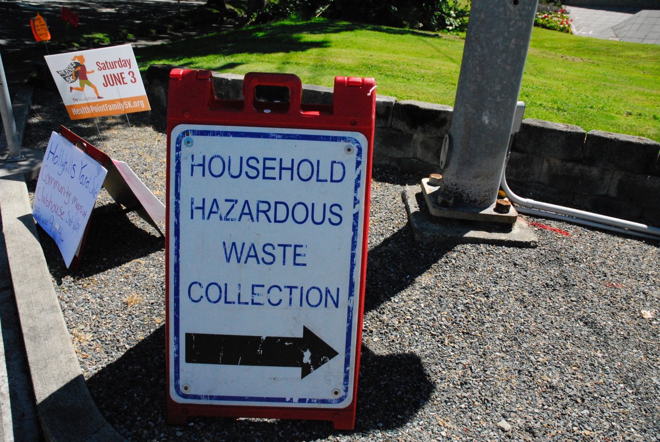 Image of a sign on the sidewalk that reads "Household Hazardous Waste Collection"
