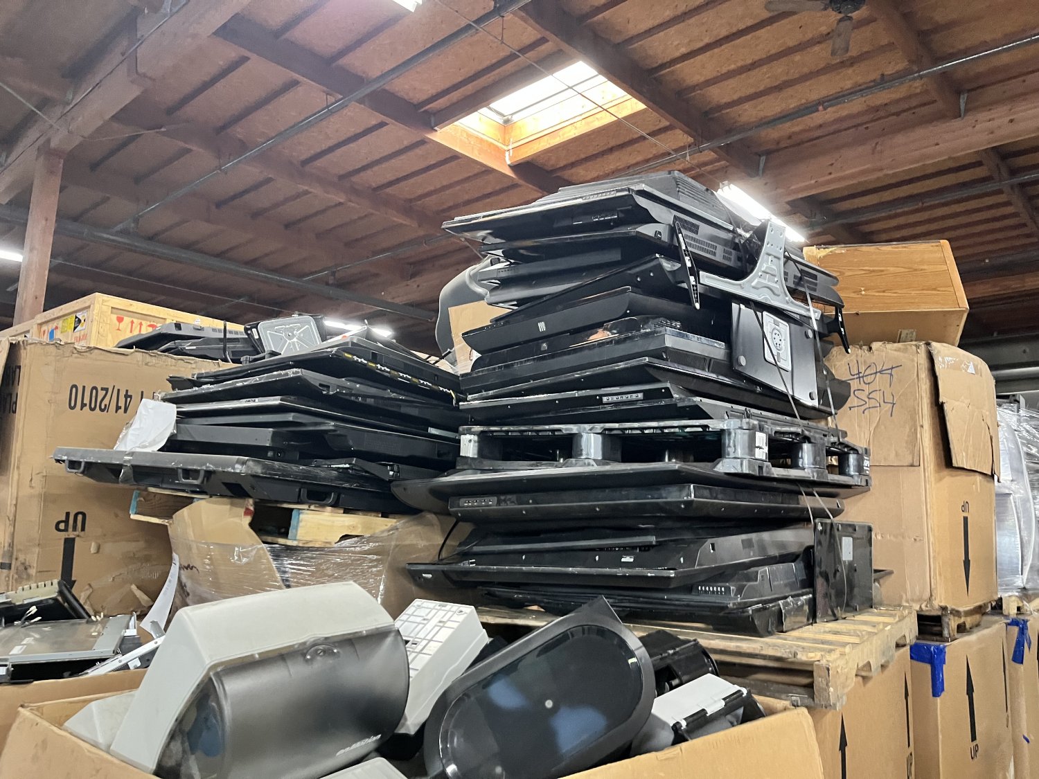 Pile of used electronic tvs and monitors in warehouse