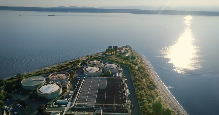 Aerial view of Puget Sound near West Point Treatment Plant. The sun is setting across the water. 