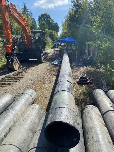 Pipeline segments are staged next to the trail prior to assembly. 