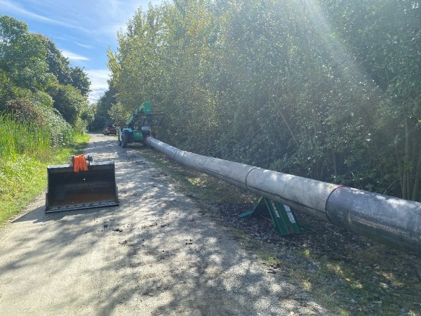 A temporary pipeline (above ground) is being set up next to the trail. 
