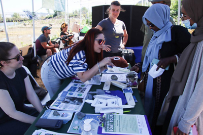 a group of people surrounding a table with flyers and communication materials
