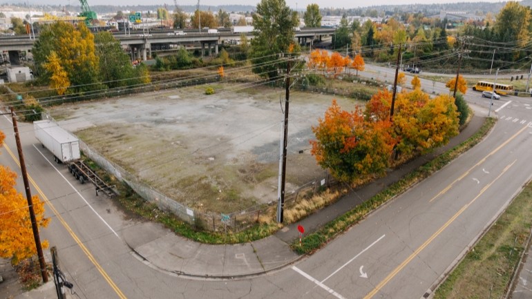 Project site at the intersection of Southwest Michigan Street and Second Avenue Southwest. Currently the site has been cleared with fencing to secure the site. Photo taken in October 2025.