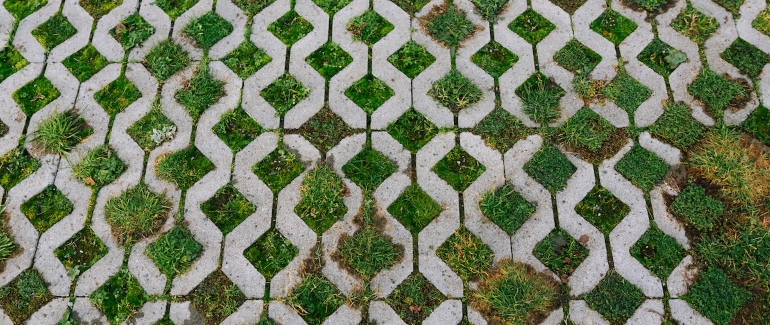 Closeup of pervious pavers, which looks like a concrete grid with grass in the gaps. 