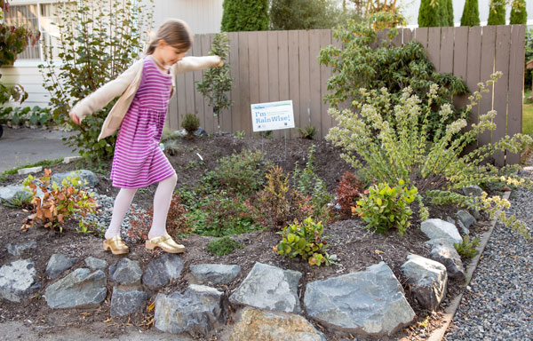 girl in pink dress walking through a rainwise garden