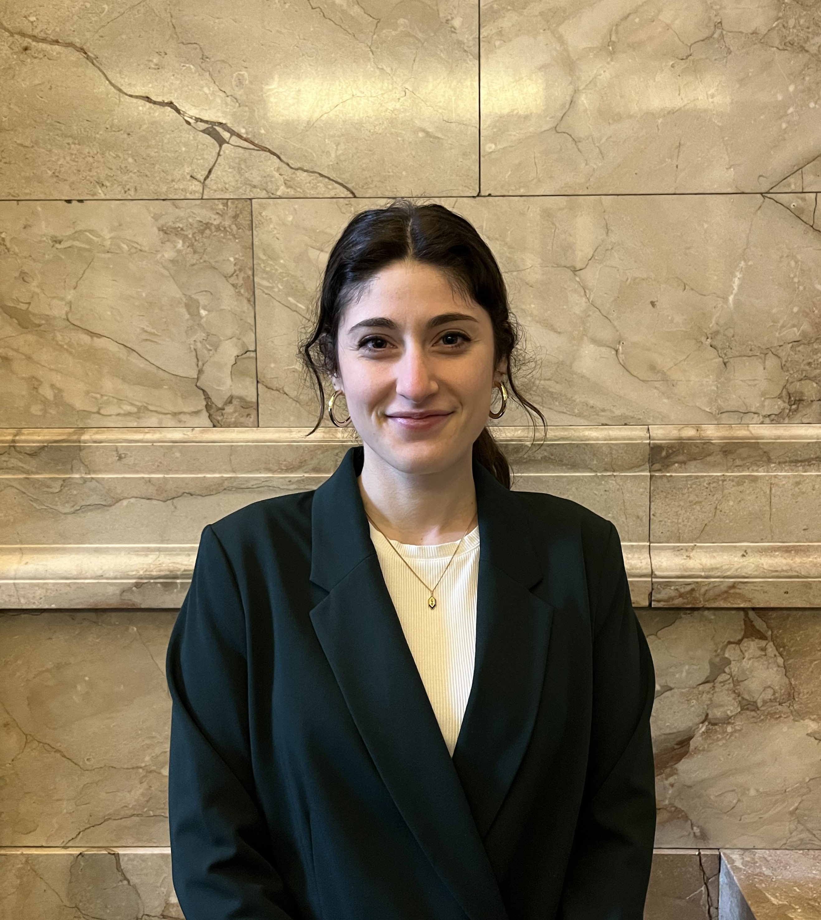 Marissa Miller, defense attorney in DPD's Seattle Municipal Court practice, in a dark blazer and white shirt against a marble backdrop