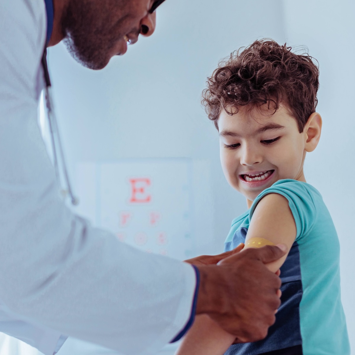 A child getting a bandage after immunization from a health provider