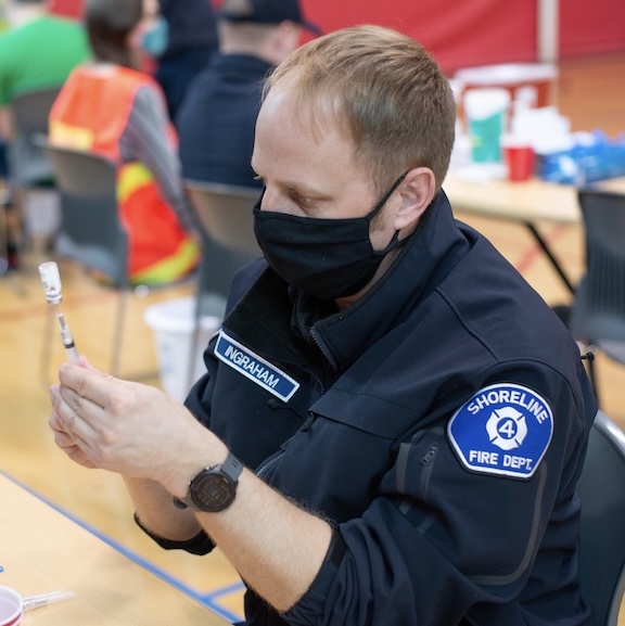 A Shoreline Fire Department employee preparing to give vaccine