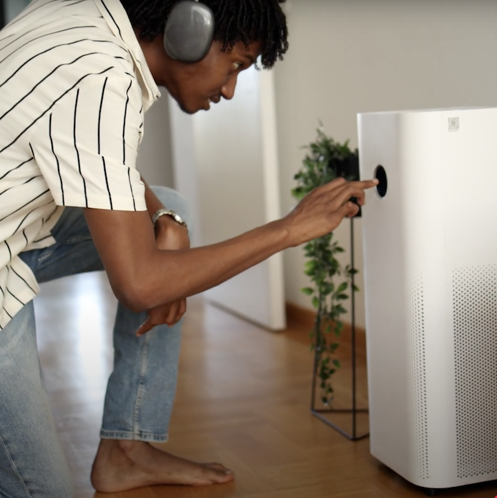 Young man adjusting a HEPA air filter system