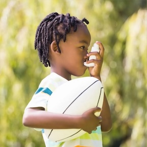 School age boy using an inhaler to end an asthma attack