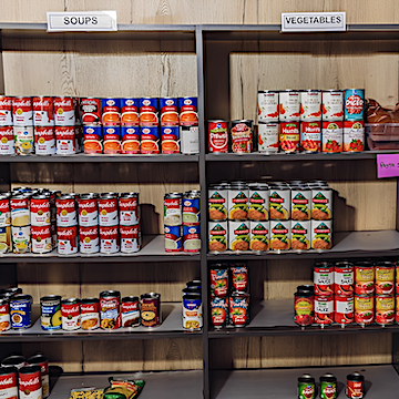 Shelves at a food bank filled with donated canned goods