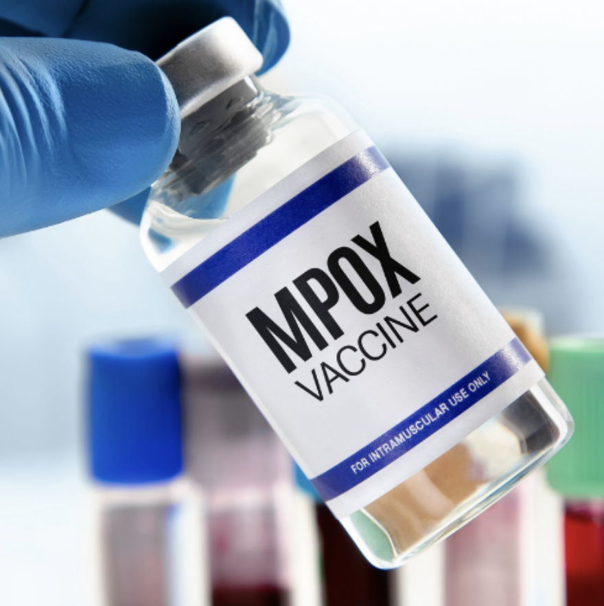 Holding up a vial of Mpox vaccine