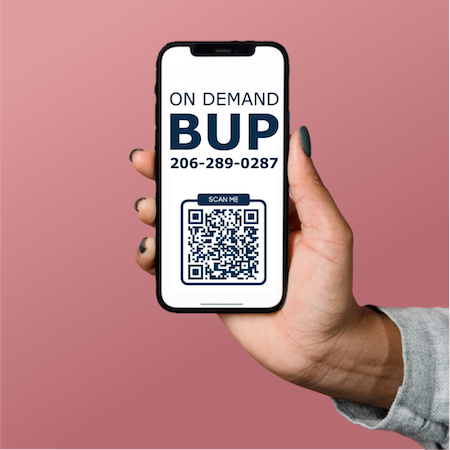Person holding up a mobile phone with wording about a Tele-Bup phone service with QR code pointing to a related website at the University of Washington