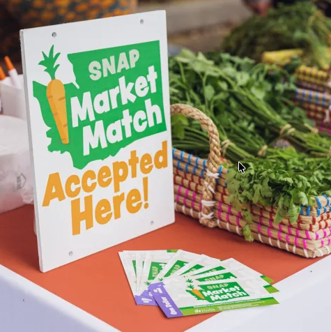 A sign at a farmers market indicating that SNAP benefits are accepted here