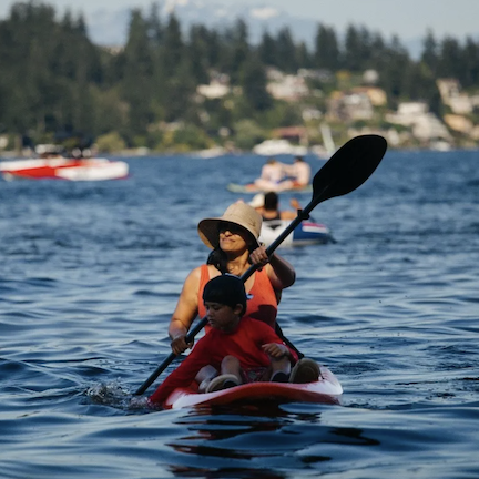A mom and her child on a kayak on a lake