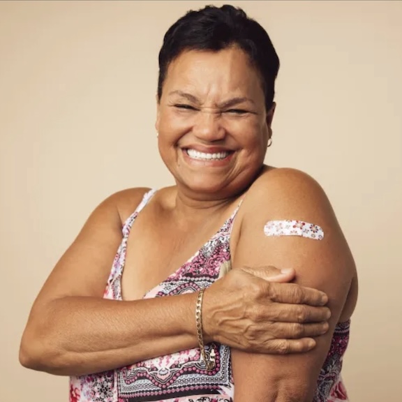 Middle-aged woman smiling after having received an immunization