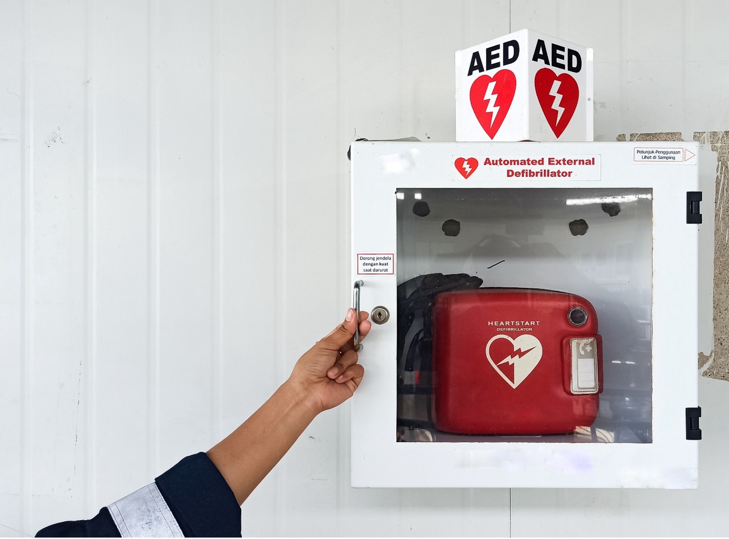Person opening the protective box holding an AED device