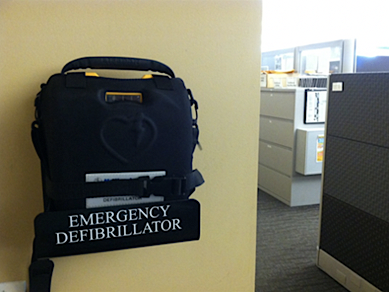 Wall-mounted AED unit in an accessible area in an office