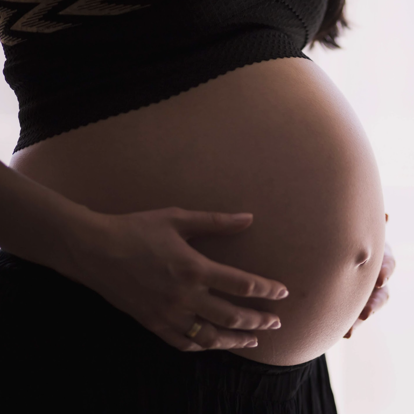 pregnant person holding belly