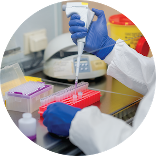 A lab worker wearing PPE using a pipette in an infectious disease lab setting