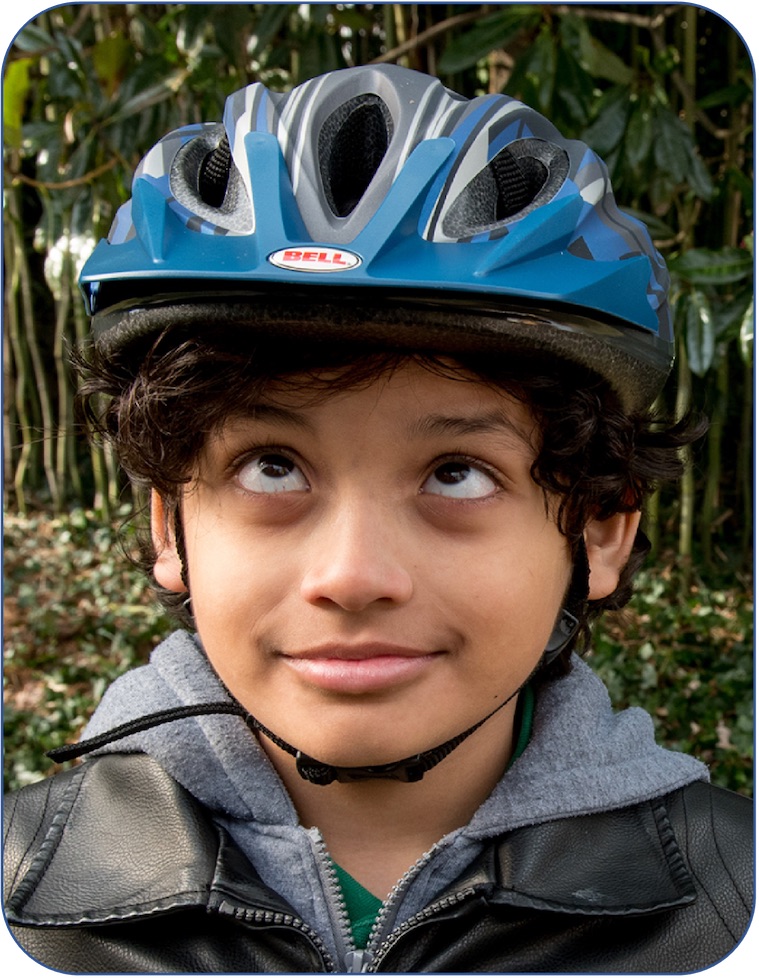 Young boy staring up at his bike helmet