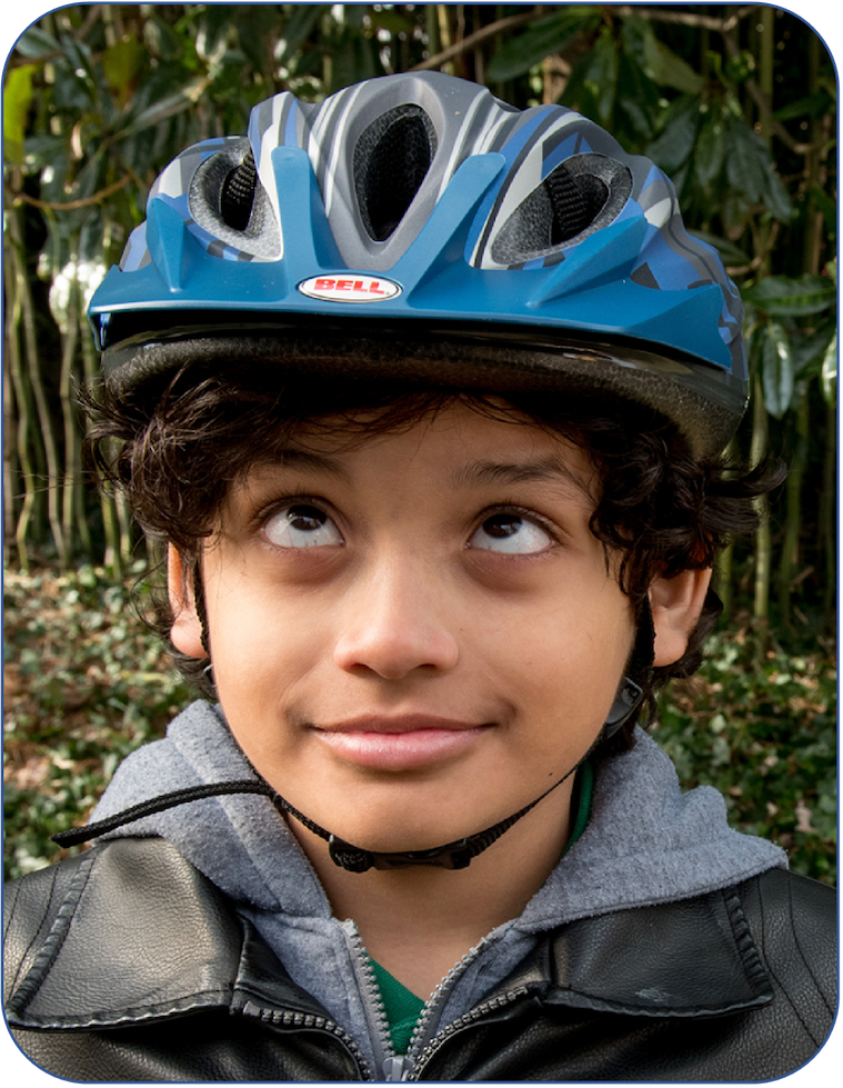 Young boy staring up at his bike helmet