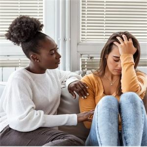  Image of a woman consoling and supporting another woman in distress over drug-related overdose