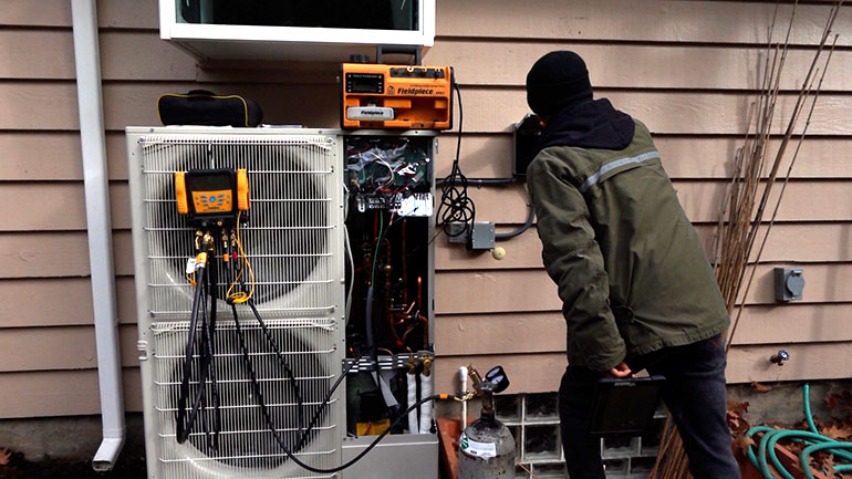 worker installs heat pump at a home
