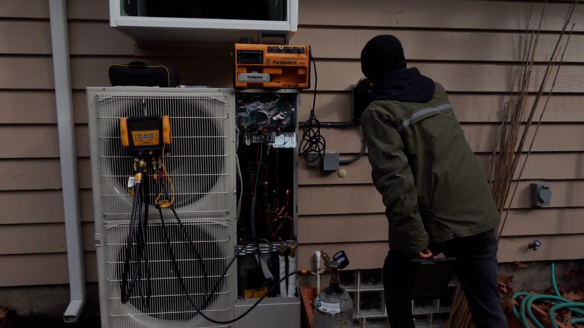 worker installs heat pump at a home