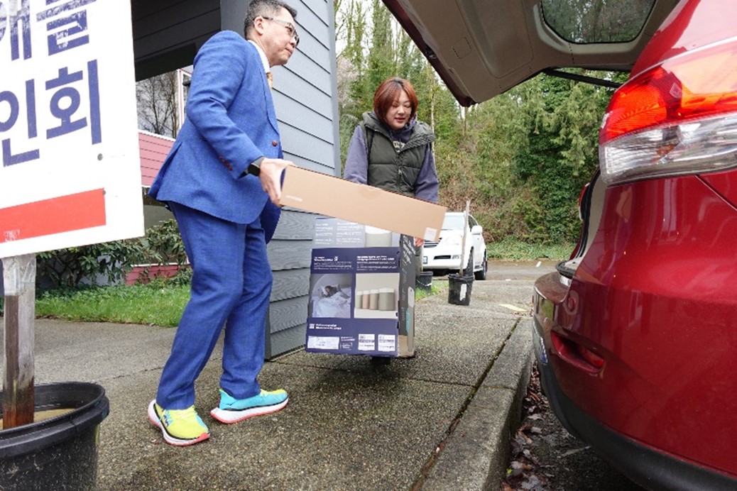 person loads air purifier into trunk of car