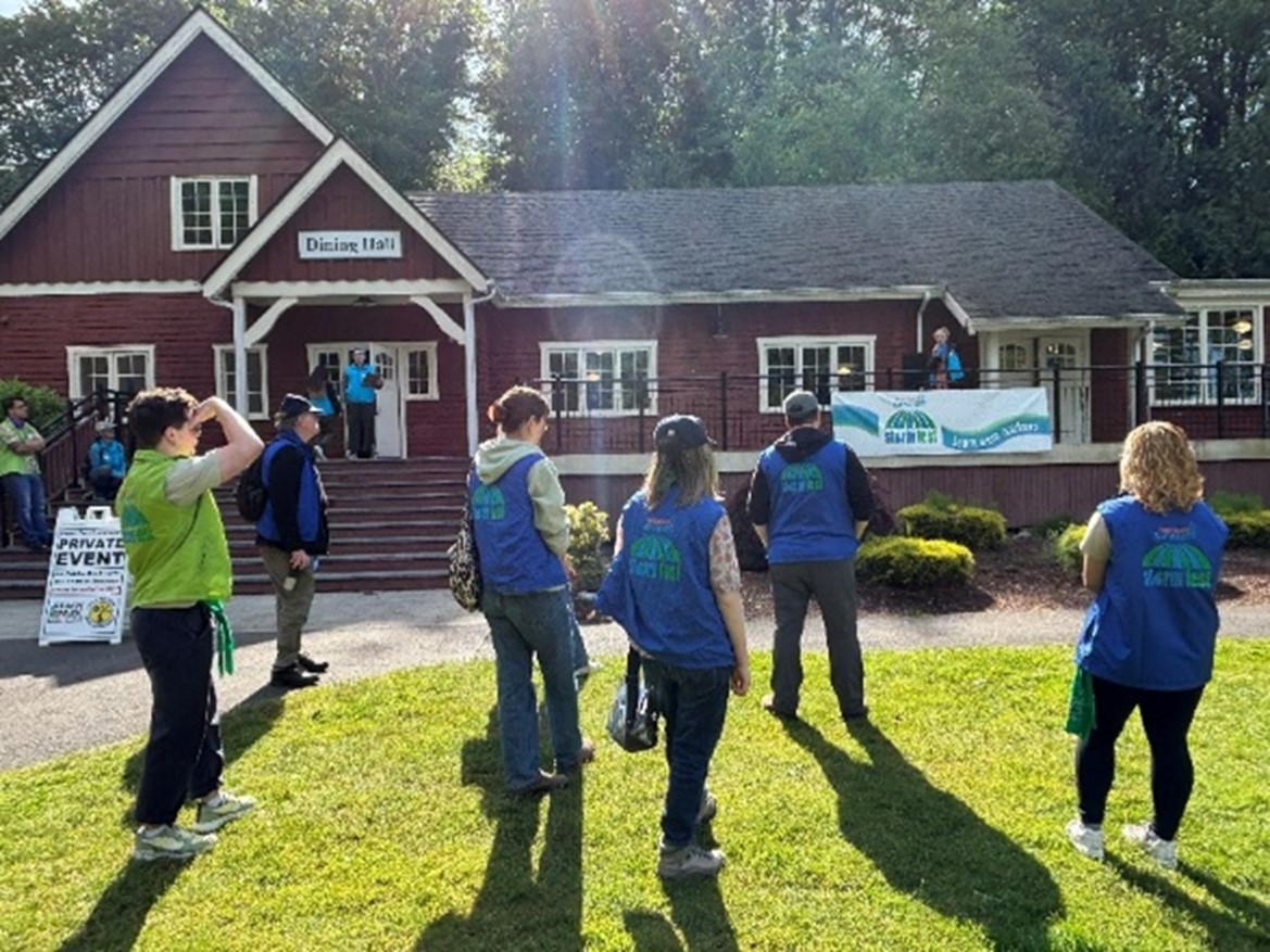 group of people standing outside wearing blue vests
