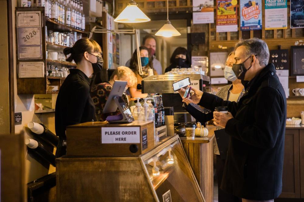 Executive Dow Constantine showing his vaccine verification at a coffee shop. 
