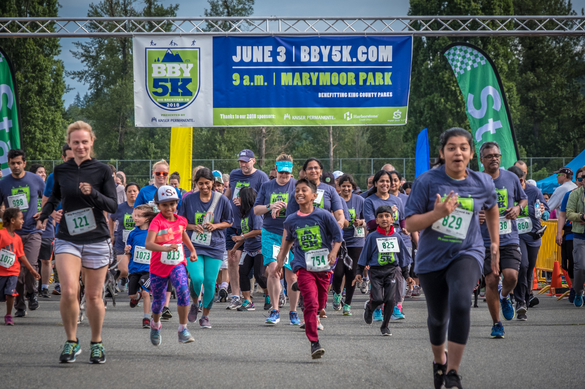 Children and adults running in a road race.