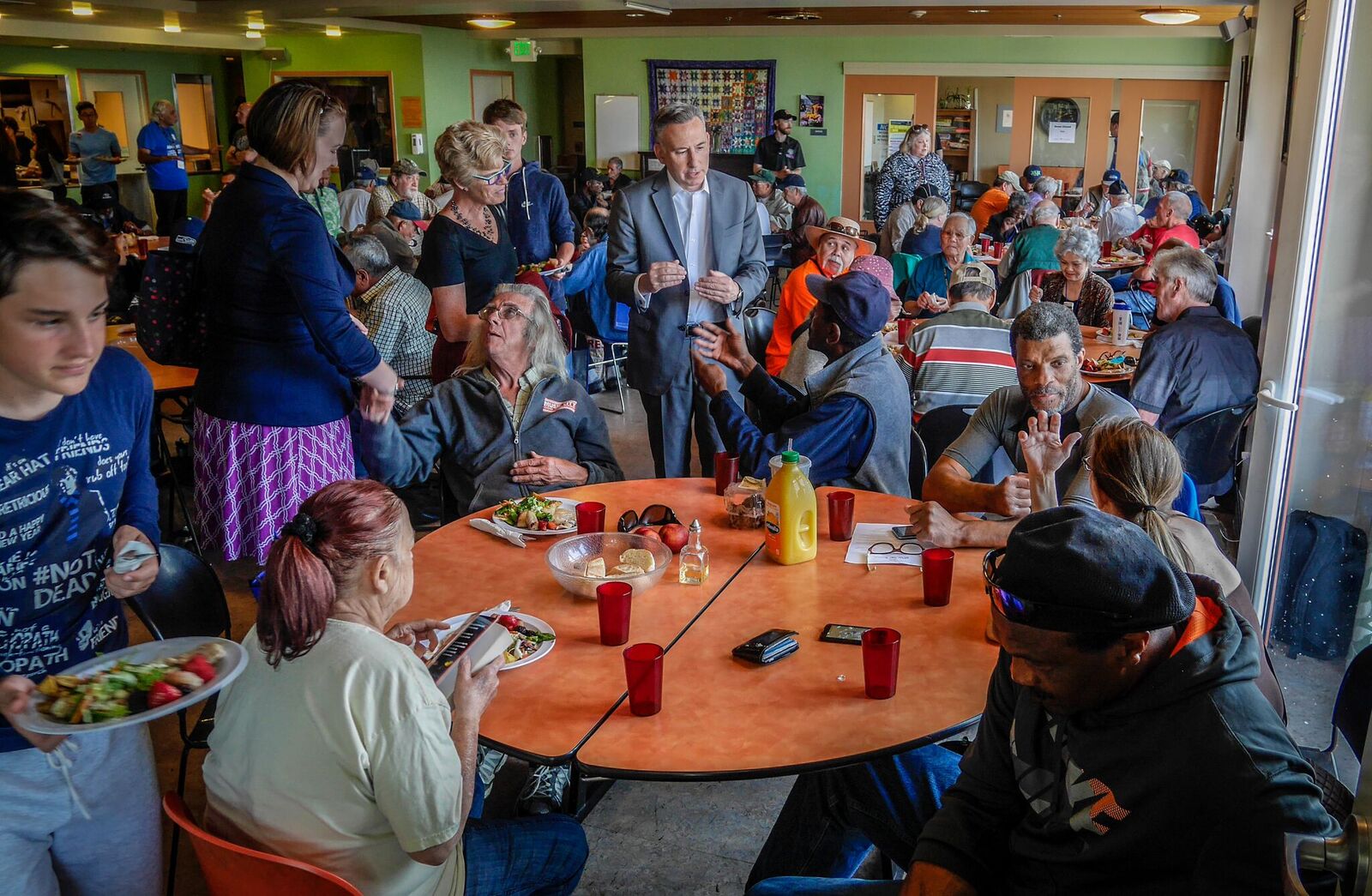 Executive Constantine talking to a table of people at Pike Market Senior Center and Food Bank.