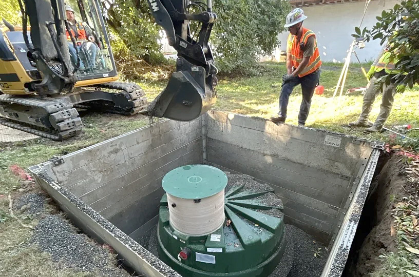 Workers and equipment bury a new septic tank