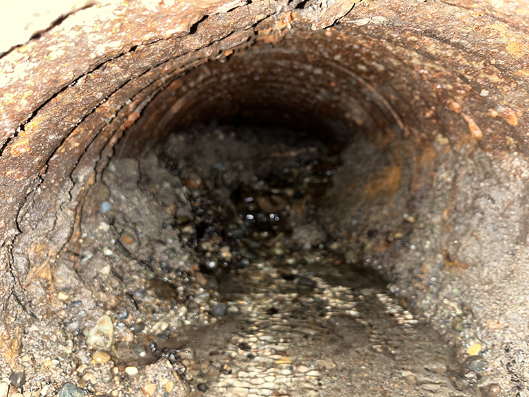 Close-up view of the existing metal pipe.