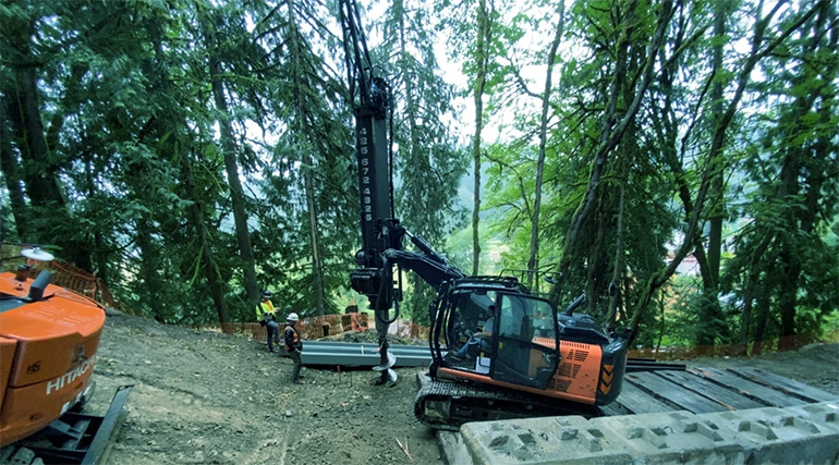 A large drill, called an auger, drills into the soil on 244th Ave NE to prepare for the new steel soldier piles.