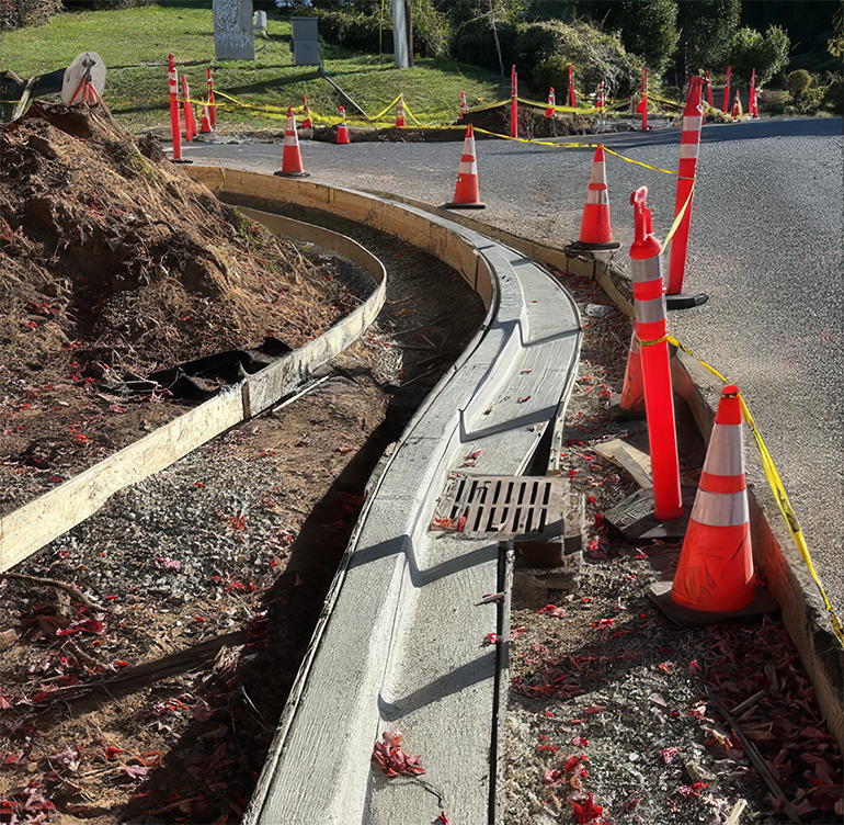 Freshly placed concrete curb and construction cones