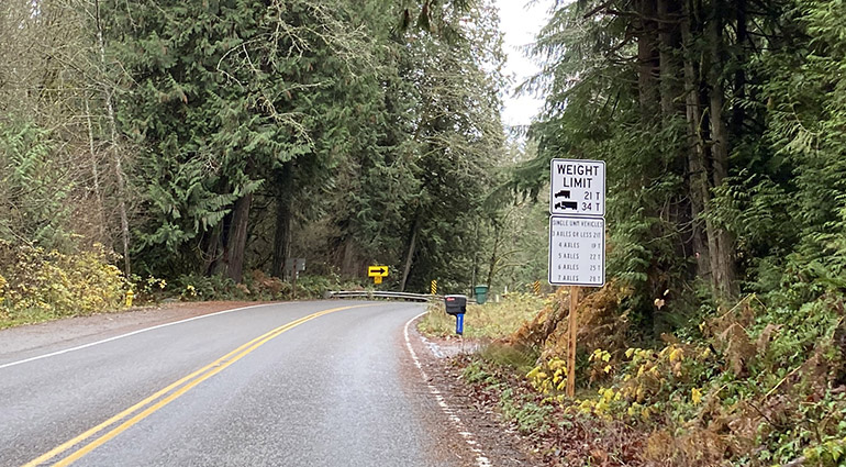 A sign provides details about which types of trucks are restricted from using the bridge