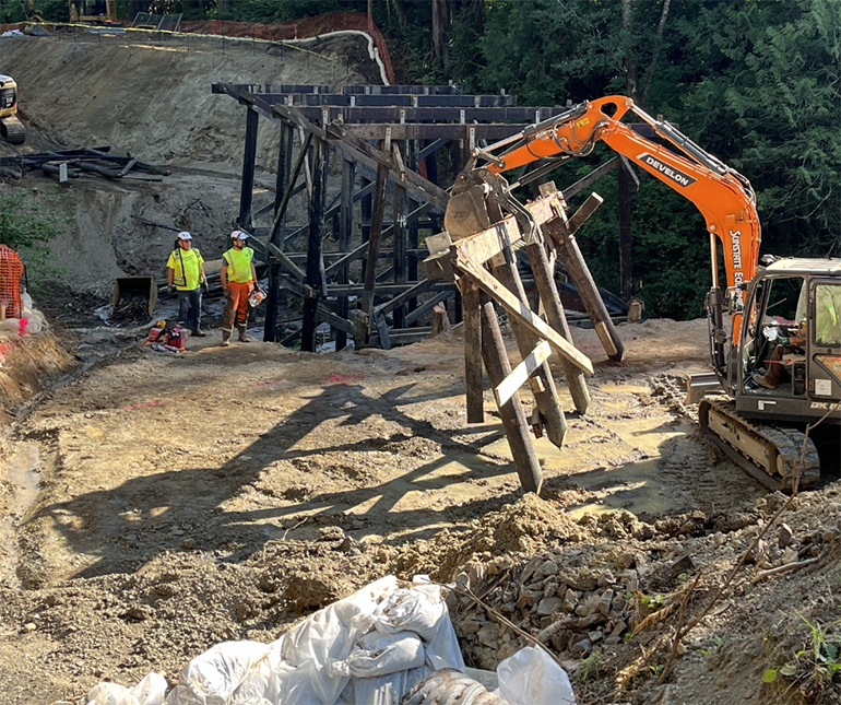 Crews take the final major step in bridge demolition by removing the existing creosote-treated timber piles. 