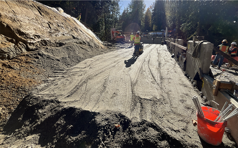 A crewmember uses a vibrating compactor 